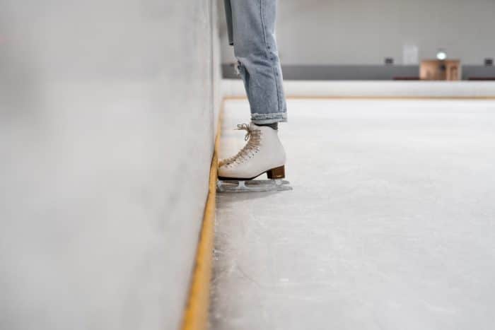 Sortie patinoire 1 person wearing white and gray skate shoes inside ice skating rink