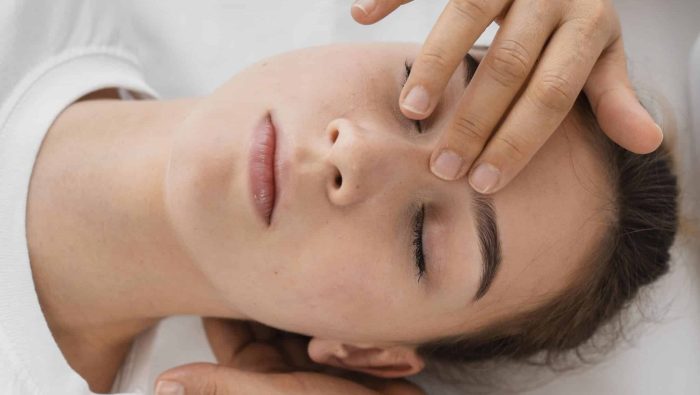 osteopathe traitant patient massant son visage scaled e1677158544904
