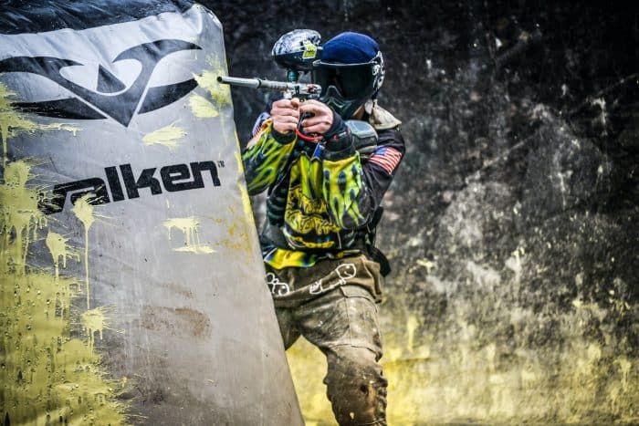 Paintball 1 man in green and black camouflage uniform holding black and white banner