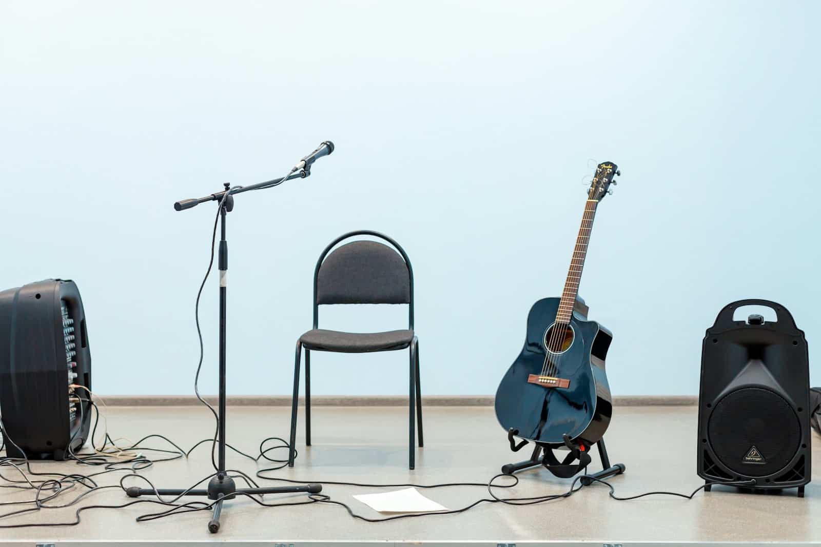 black acoustic guitar on black steel chair