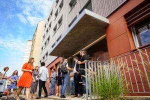 Inauguration de la Somme : le groupe entre dans le bâtiment, constitué d'une façade rouge et grise.