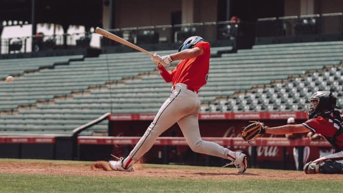 Initiation au baseball 1 woman in red jersey shirt and white shorts holding baseball bat