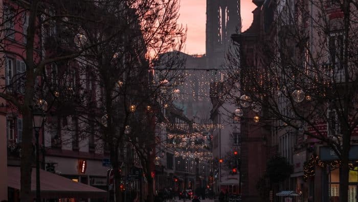 cars parked on sidewalk near high rise buildings during night time